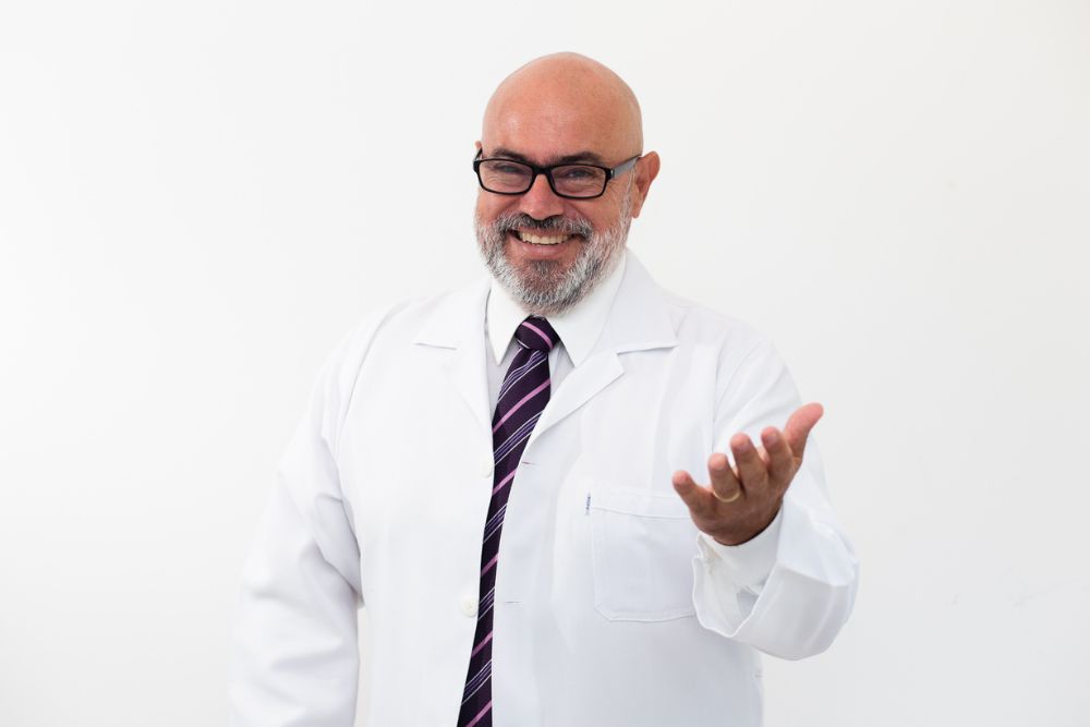 Dr. Jô Furlan sorrindo, usando jaleco branco